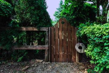 Old wooden fence and wicket in home garden
