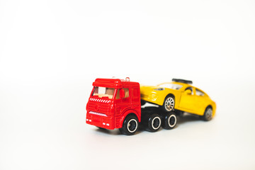 Miniature red trailer lift up broken yellow taxi isolated on white background using as...