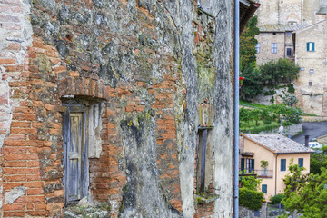 Old weathered window on a brick wall in a village