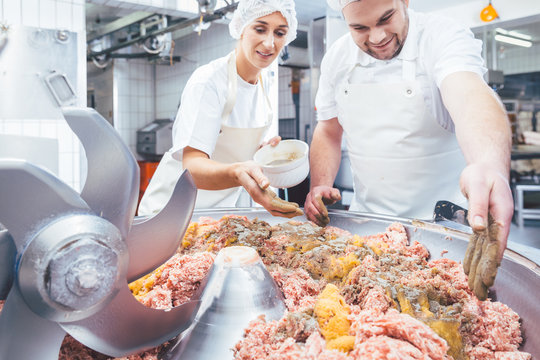 Fleischer w&uuml;rzen das Hackfleisch als Wurst Rohmasse