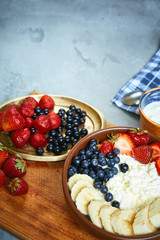 bowl of cottage cheese with berries, bananas and sour cream
