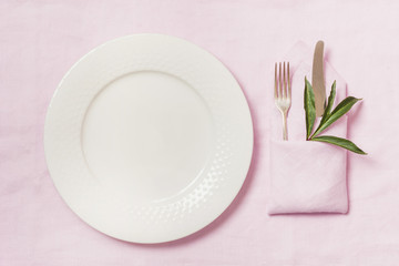 Romantic dinner. Elegance table setting with plant on pink linen tablecloth. Top view.