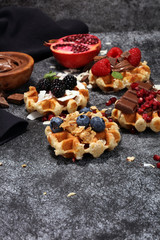 Belgian waffles with pomegranate and raspberries, homemade healthy breakfast with mint
