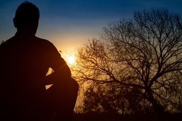 Man meditating in the field at sunrise