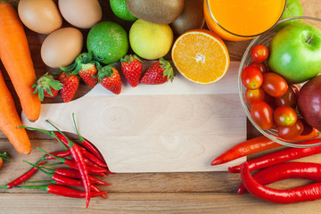 Healthy concept with mixed fruits and vegetables on wooden background