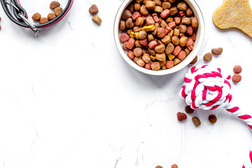 dry dog food in bowl on stone background top view