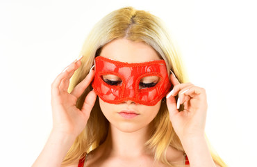 Woman on mysterious face play role game, visit masquerade. Girl with long blonde hair wears mask. Lady with long white manicure hold mask on face, white background, isolated. Mysterious woman concept.