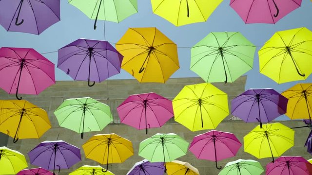 Camera Pans along Colorful Umbrellas hung above street