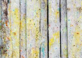 splashes and colored paint stains on the wall of old wooden planks after paintball. bright multicolored background