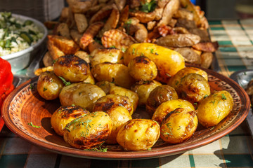 Whole roast potatoes on baking trays.