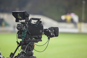 TV camera at the stadium, broadcasting during a football (soccer) match