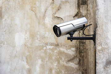 Surveillance camera on the wall background