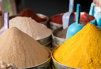 Large piles of exotic colourful spices in moroccan market