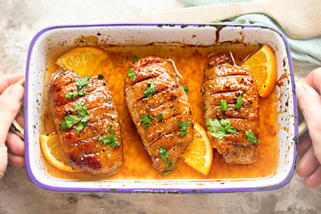 Duck breast in orange sauce marinade - dish held in hands