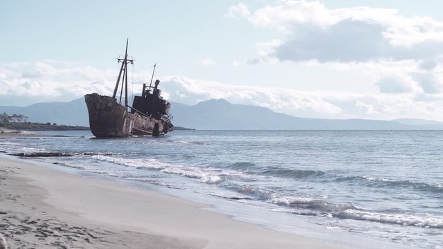 An old abandoned shipwreck, wrecked boat sunken ship stand on beach coast.  Accident at sea 4K