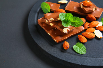 chocolate with almonds on dark grey background.