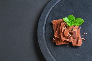 Chocolate on dark stone background. Top view with copy space.