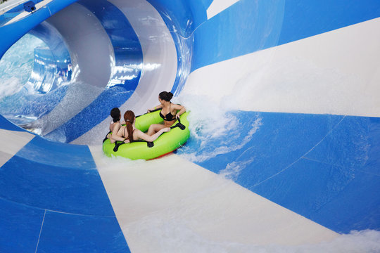 Children on water slide at aquapark. Summer holiday.