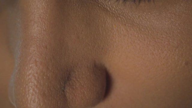 Extreme close-up of a transgender woman applying makeup