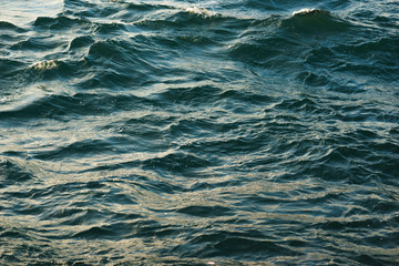 Surface of the sea with small waves of turquoise color.