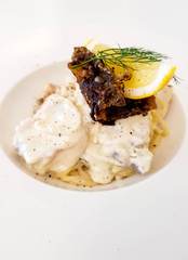 Spaghetti with bass lemon and rosemary in top on the white plate