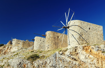 Ancient windmills against a bright blue sky of Lasithi Plateau on Crete, Greece