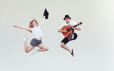 Man with guitar and woman jumping