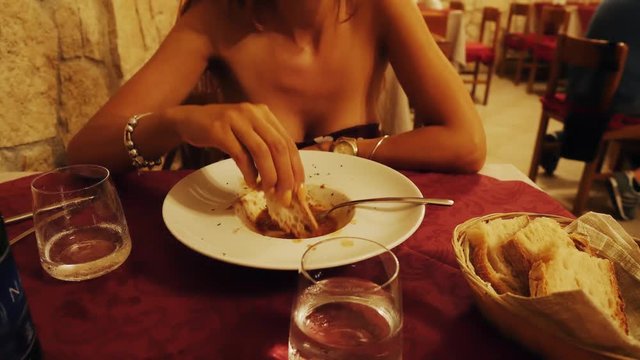 Girl in restaurant eats caciucco a typical italian dish.