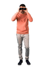 Full body of  Man in a pink sweatshirt and looking for something in the distance on isolated white background