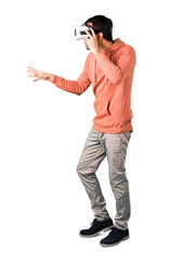 Full body of  Man in a pink sweatshirt using VR glasses. Virtual reality experience on isolated white background