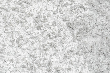 Rough Concrete Wall Decoration, Painted White. White Concrete Wall with Many Protruding Stones.