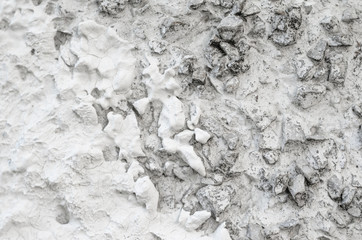 Rough Concrete Wall Decoration, Painted White. White Concrete Wall with Many Protruding Stones.