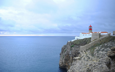 Fototapeta na wymiar Amazing lighthouse on cliffs at Cape St. Vincent. Algarve, Portugal. The most extreme geographical point in the southwest of Continental Europe