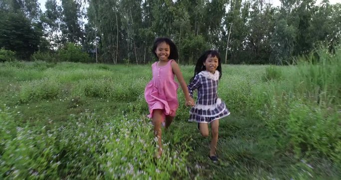 4K Two little girls running around the park