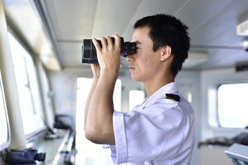 Chinese Junior Navigation Officer Navigating his Ship