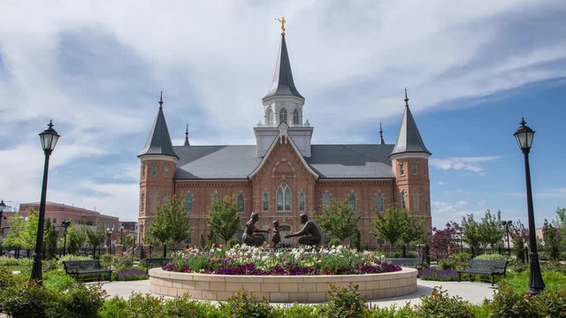  Time lapse of the Provo City Center Temple with flowers in bloom as clouds move through the sky.