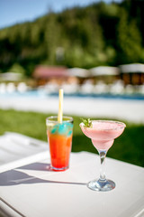 Two luxury summer cocktails on the table near the swimming pool outdoors