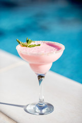 Close-up of summer cocktail on the beautiful blue water background during the sunlight