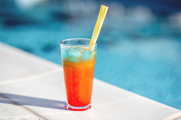 Close-up of summer cocktail on the beautiful blue water background during the sunlight