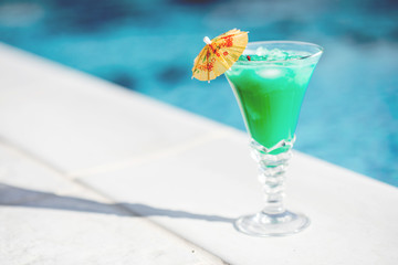 Close-up of summer cocktail on the beautiful blue water background during the sunlight
