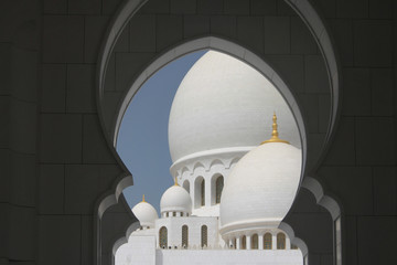 kopuły białego meczetu na tle niebieskiego nieba w Abu Dhabi, Zjednoczone Emiraty Arabskie  - obrazy, fototapety, plakaty