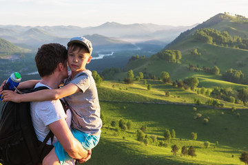 Happy father and son are walking in the Altai mountains