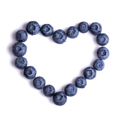Creative blueberries in the shape of heart isolated on a white background.