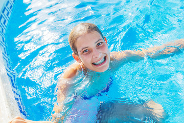 Happy girl jumping in the pool