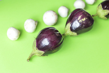 Eggplant and champignons on a green background.