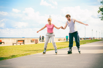 Fototapeta premium Active young people friends rollerskating outdoor.