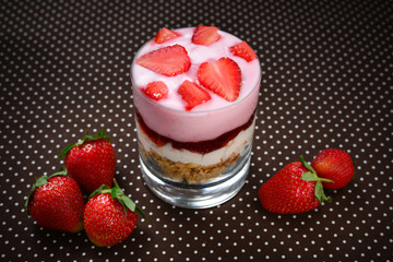 Home made granola breakfast with strawberries and plain yogurt, served in the glass.
