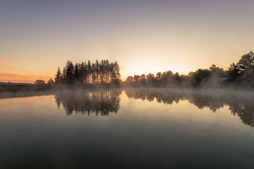 Fototapeta na wymiar Morning fog on the forest lake,