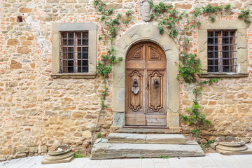 Grand wooden door in the medieval town of Volpaia, Italy.