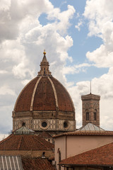 Fototapeta na wymiar The Duomo cathedral and Campanile in Florence amidst a cloud-filled blue sky.